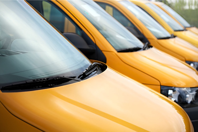 Fleet of yellow commercial vehicles with clear windshields, ready for service.