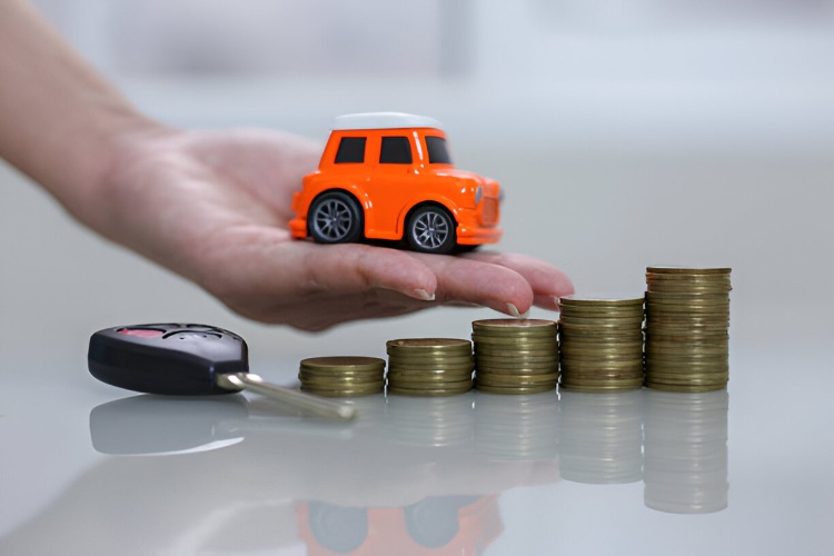 Toy car placed on a hand, next to stacked coins and a car key, symbolizing car insurance and savings.