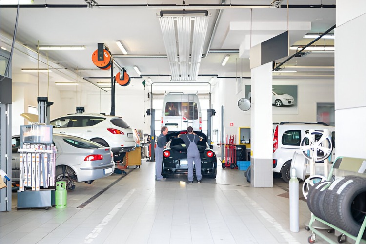 Auto technicians working on various vehicles in a service garage, focusing on repairs and maintenance.